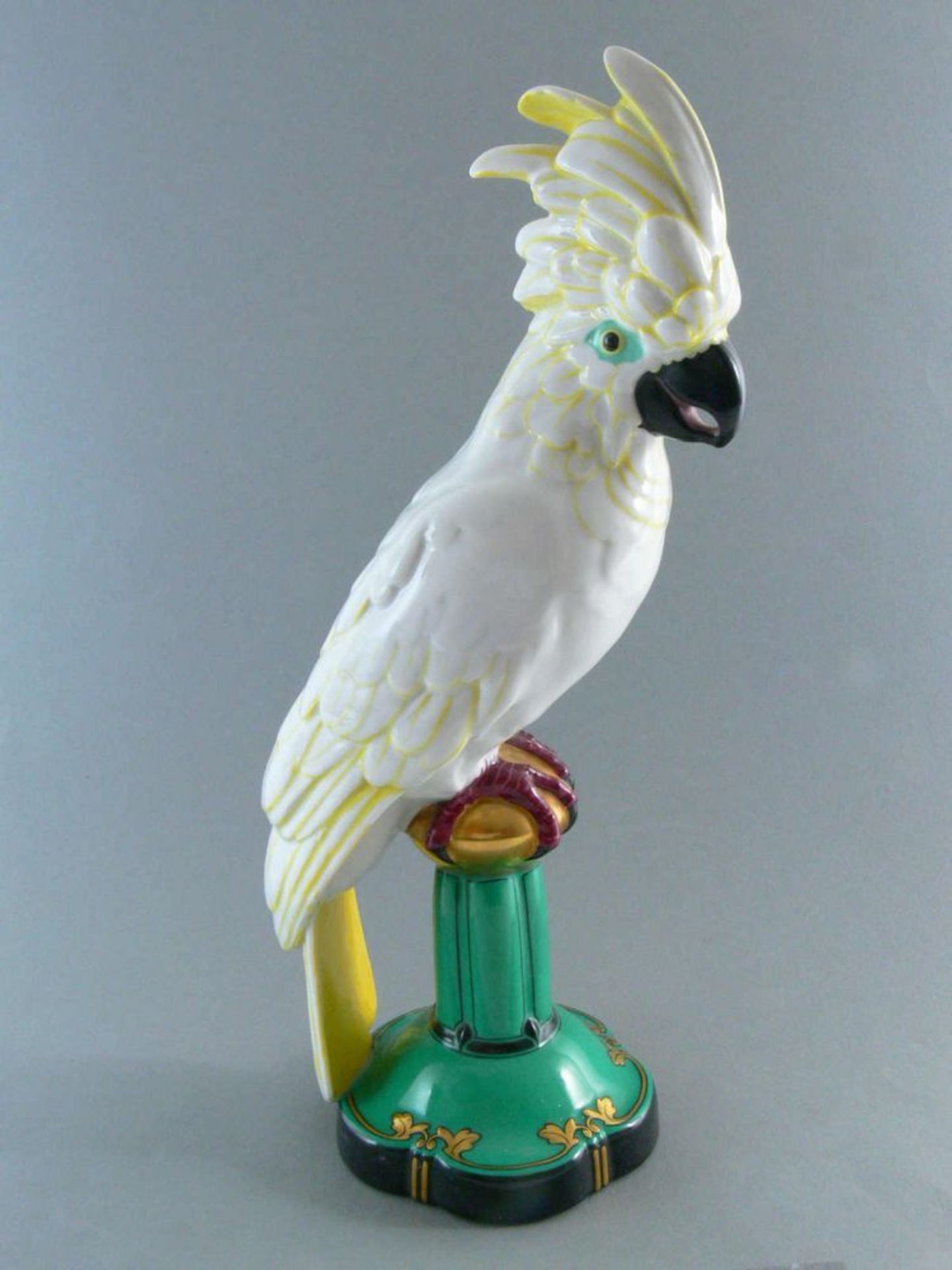 sehr große Art Deco Porzellanfigur "Papagei auf grünem Sockel", Höhe ca. 37 cm. An Boden grüne