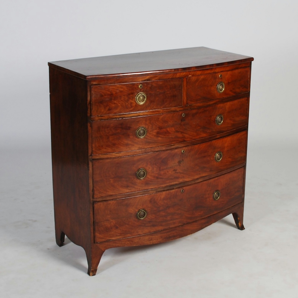 A George III mahogany bow front chest, the shaped rectangular top above two short and three long