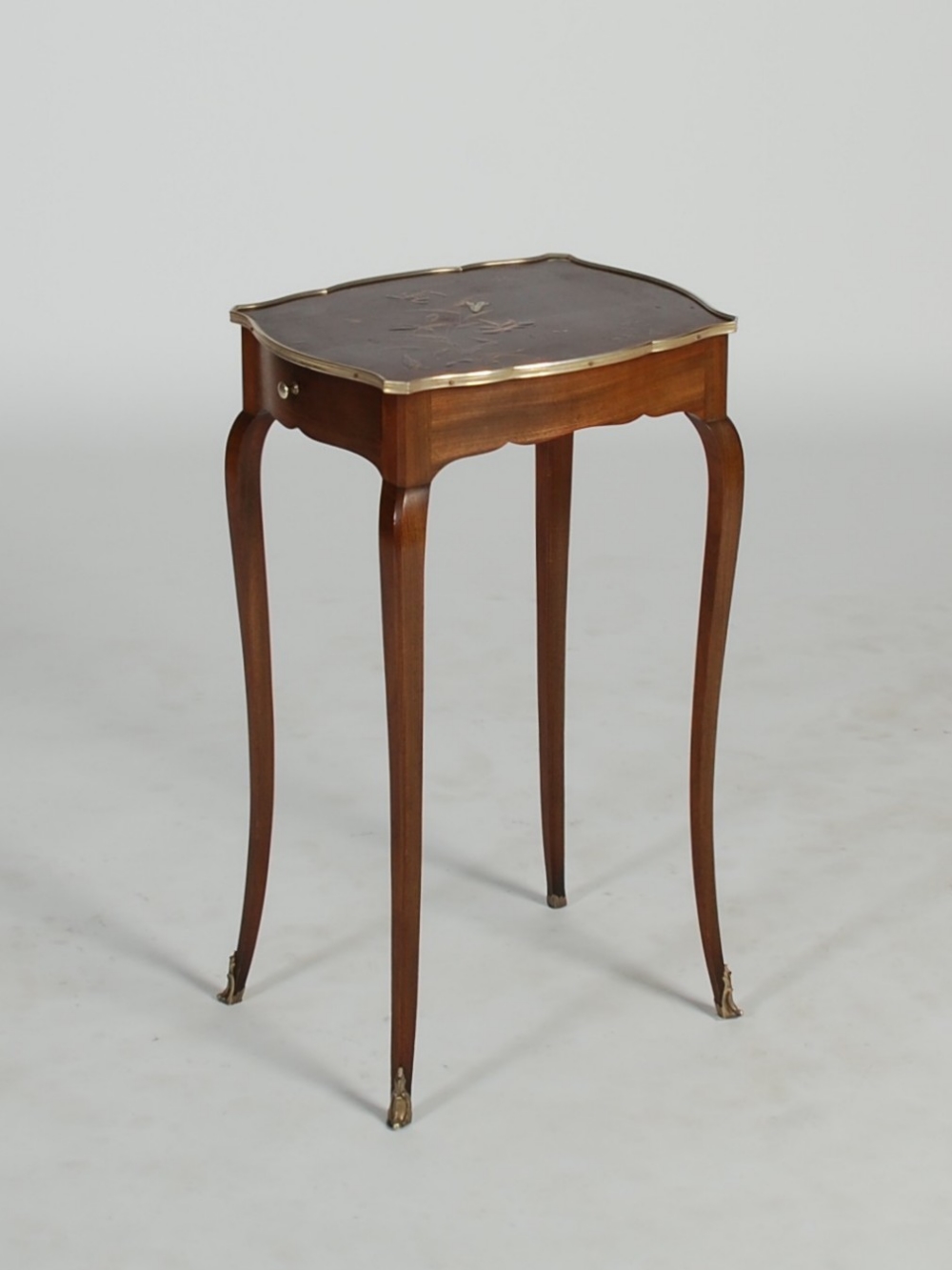 An early 20th century white metal mounted lacquer occasional table, the shaped rectangular top