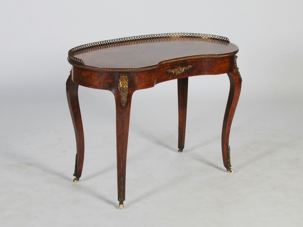 A Victorian walnut, marquetry inlaid and gilt metal mounted kidney shaped writing table, the