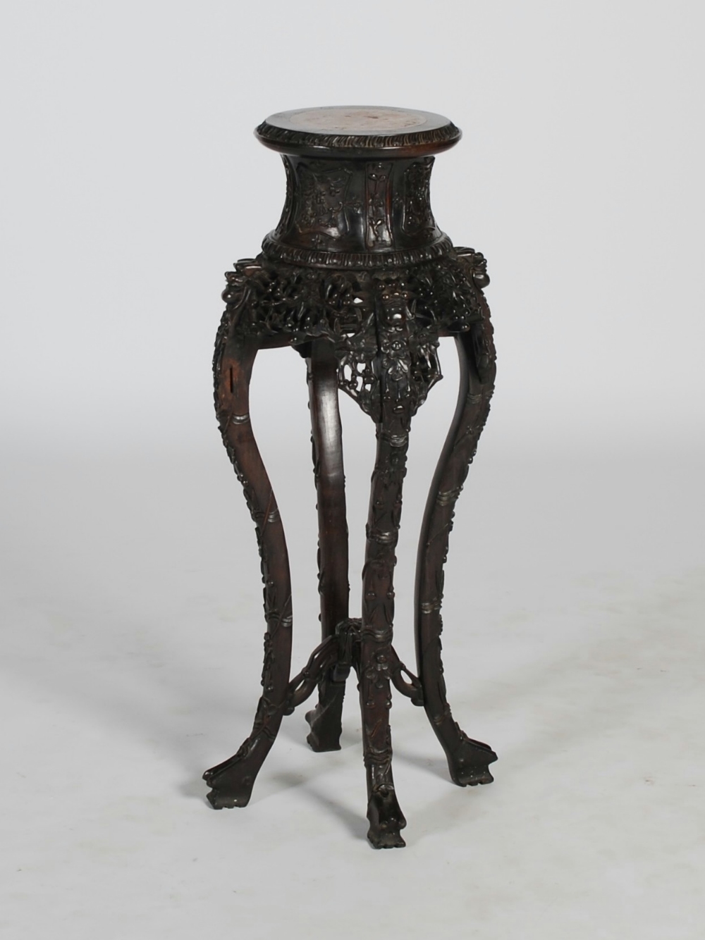 A Chinese dark wood jardiniere stand, late Qing Dynasty, the circular top with a mottled red