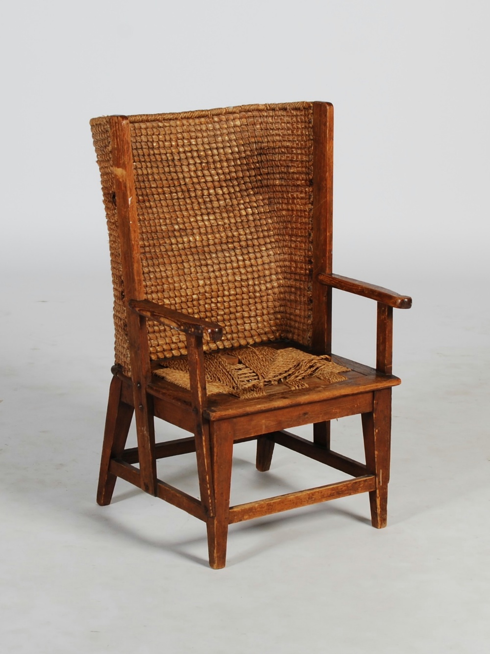 A late 19th/ early 20th century stained pine Orkney chair, the woven back above a drop-in rush woven
