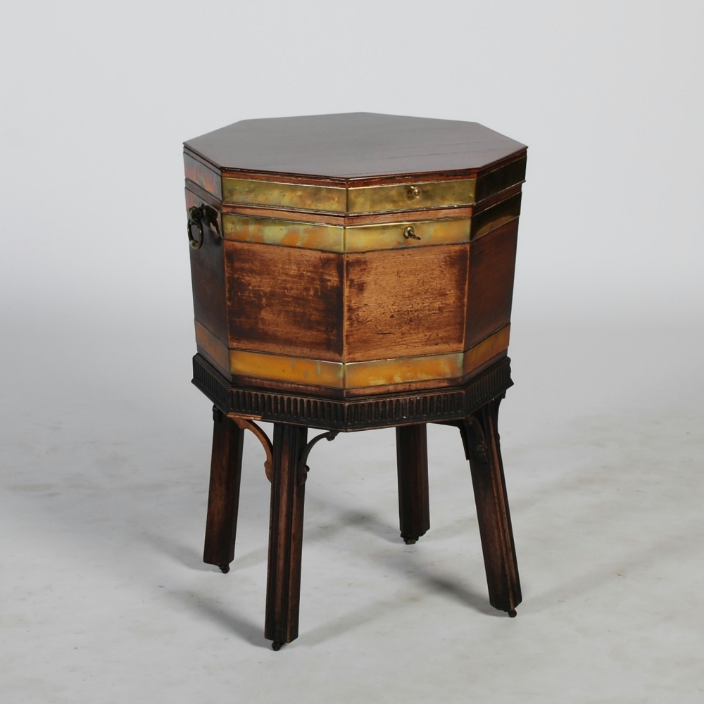 A George III mahogany and brass bound octagonal wine cooler, the hinged cover opening to a lead