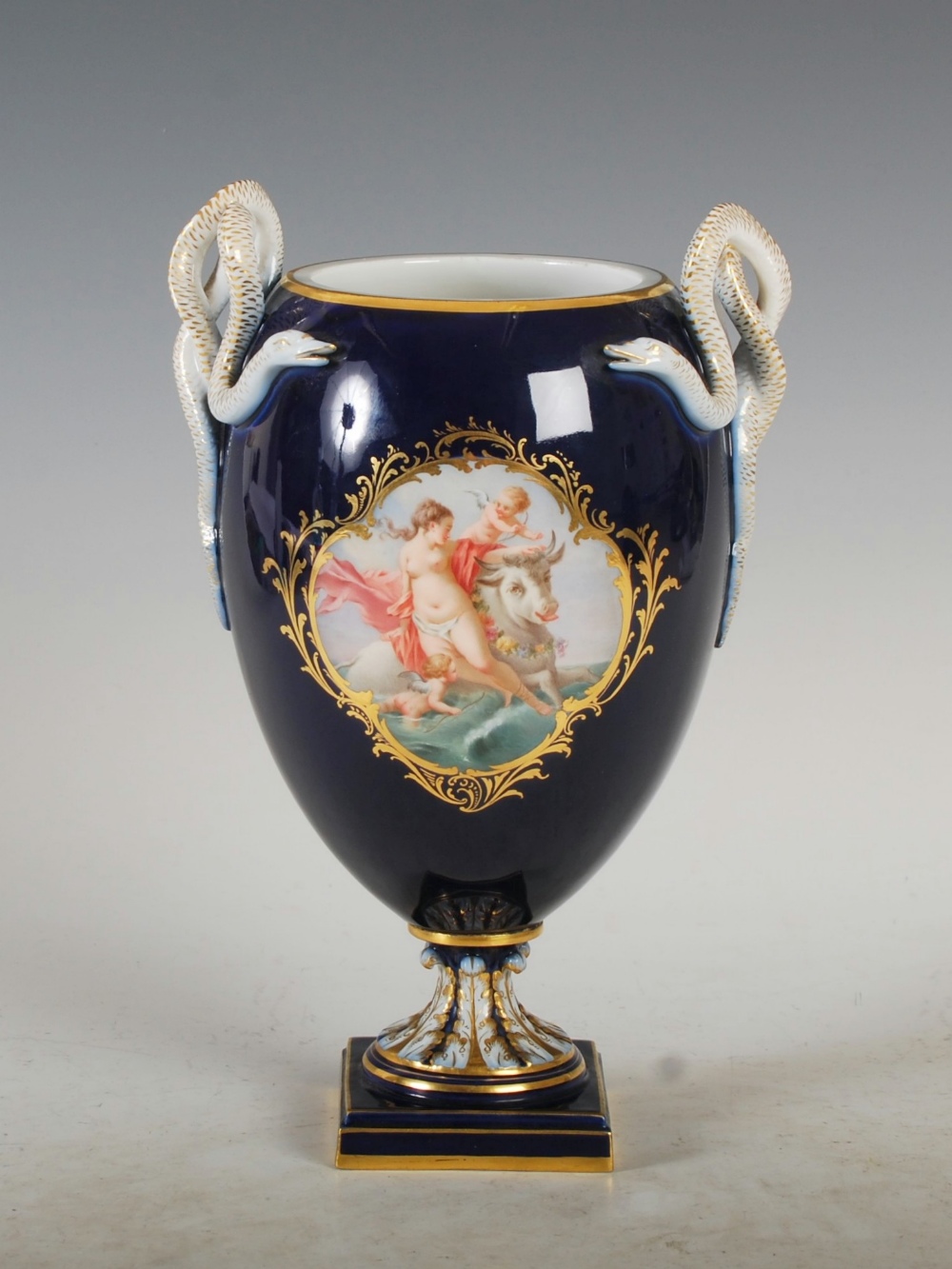 A Meissen cobalt blue ground twin handled urn, decorated with painted panels of colourful flowers,