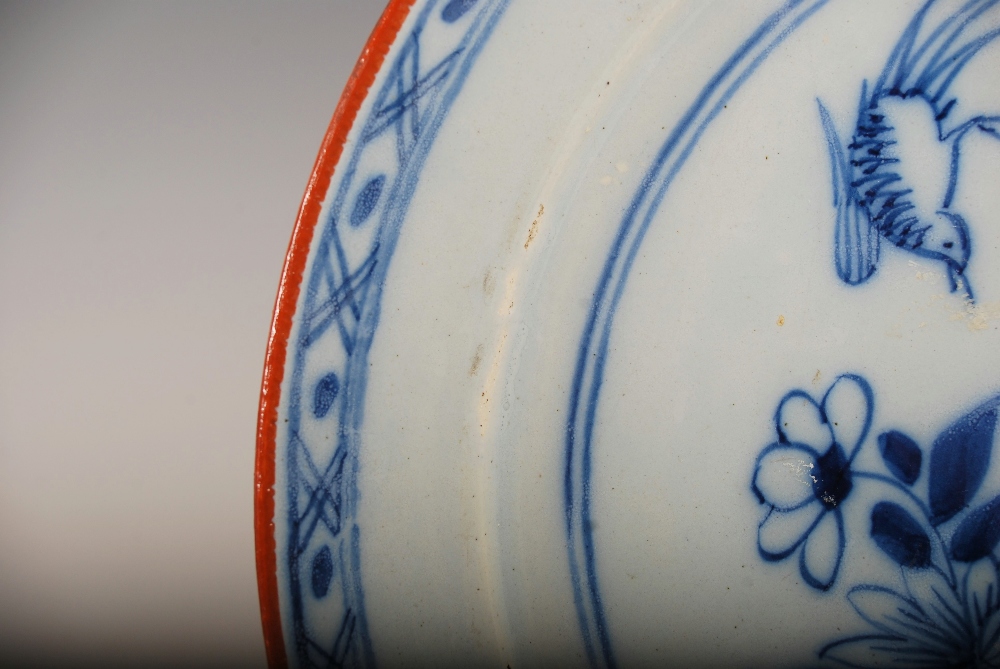 A set of three 19th century Delft plates, decorated with a garden of flowers, pine tree and bird, - Image 8 of 10