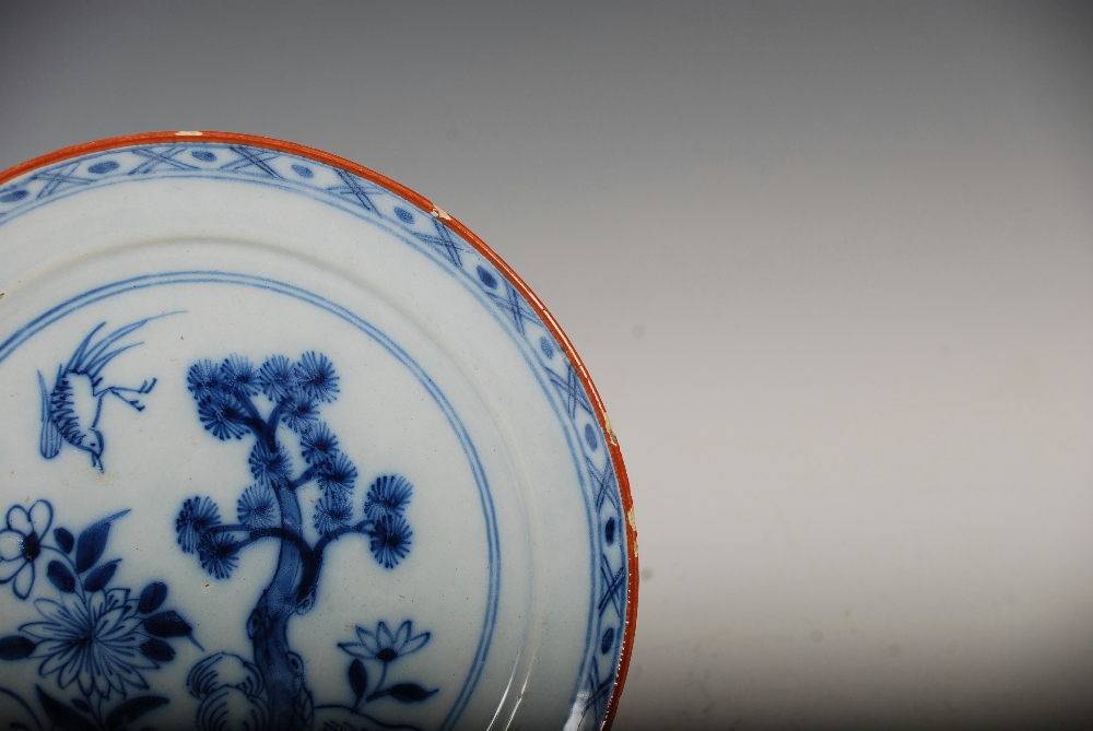 A set of three 19th century Delft plates, decorated with a garden of flowers, pine tree and bird, - Image 6 of 10