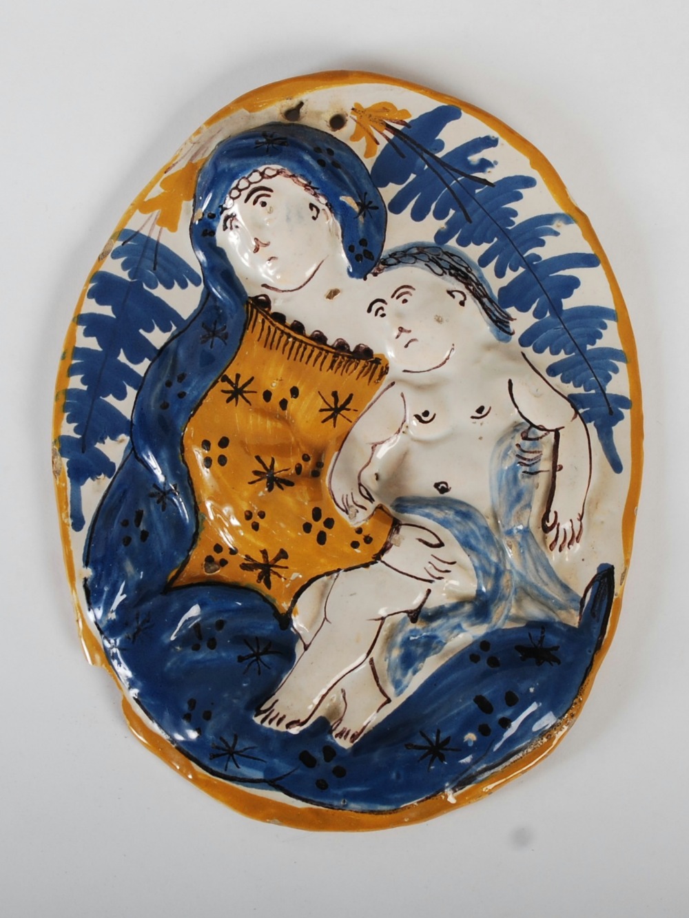 A 19th century Continental pottery oval shaped panel, decorated in relief with a mother and child