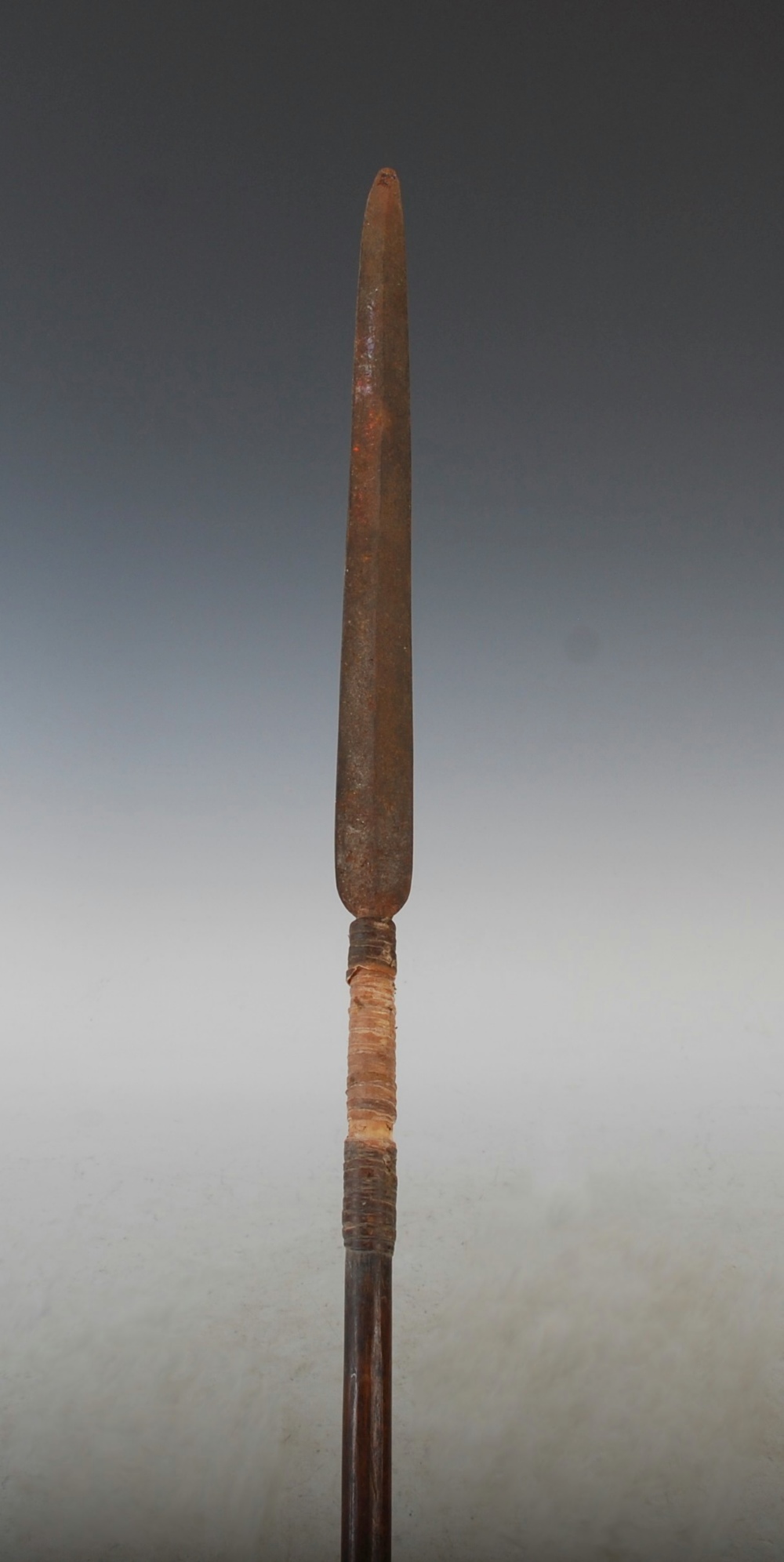 A late 19th century African Tribal spear, with a long tapered double edged blade, woven binding and