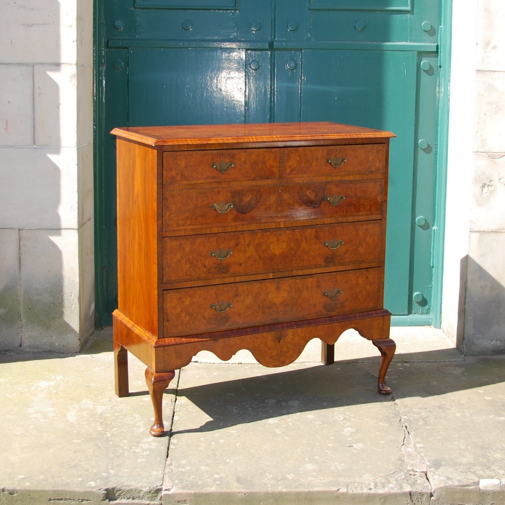 An early 20th century walnut secretaire chest, the cross banded top with a moulded edge above a