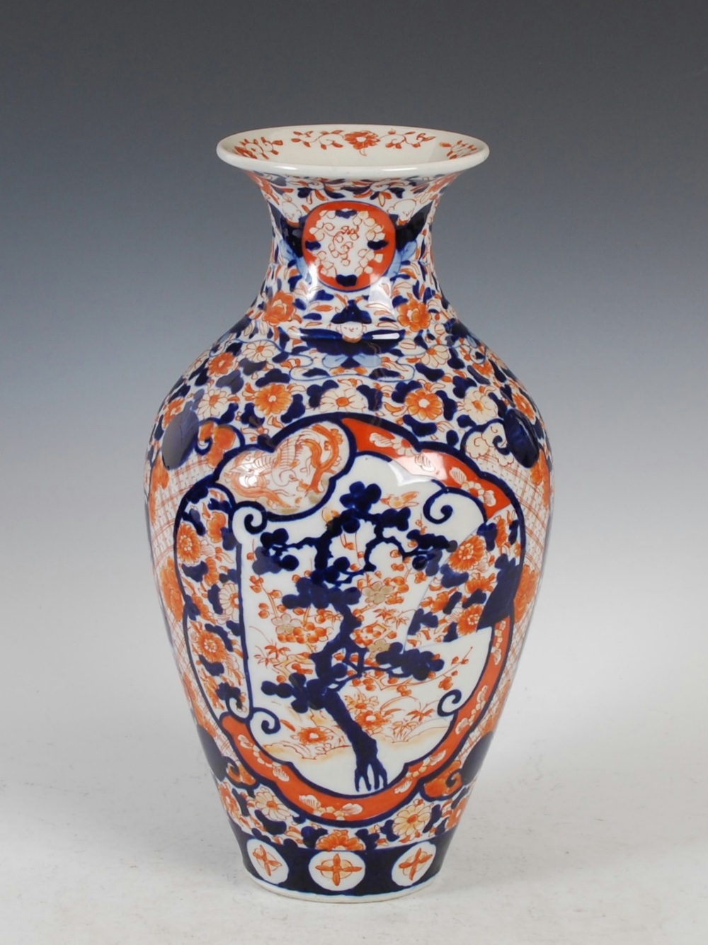 A late 19th/ ealry 20th century Japanese Imari vase, decorated with shaped panels of prunus tress on