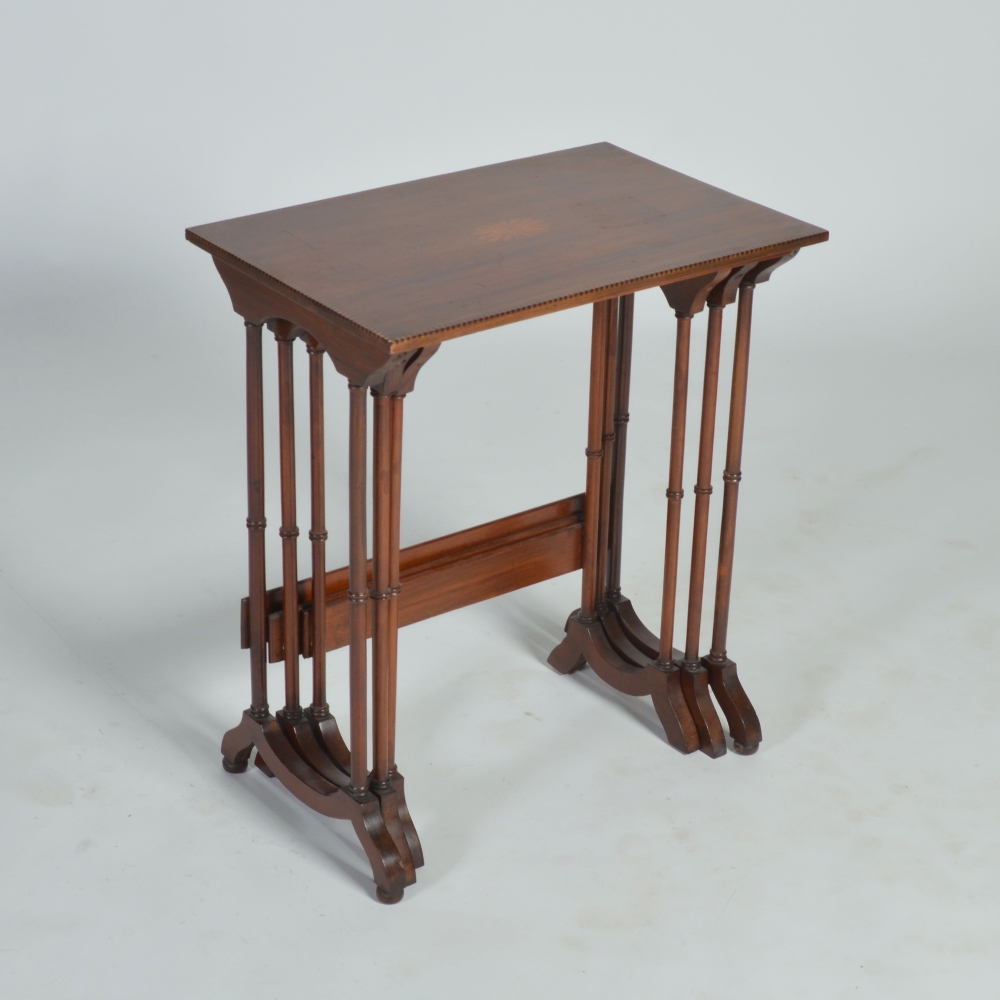 A nest of three Edwardian mahogany occasional tables, the rectangular tops centred with oval