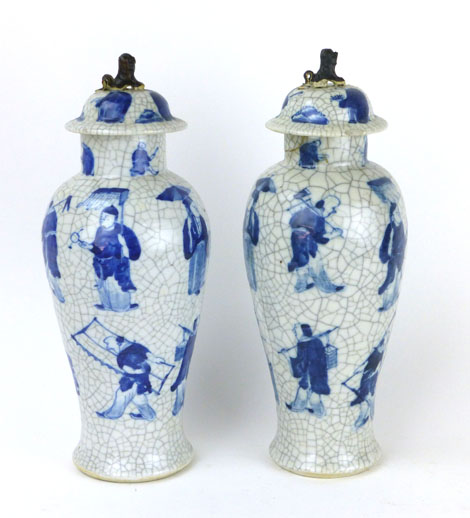 A pair of Chinese crackle glazed covered vases of slender ovoid form decorated in blue with bands of