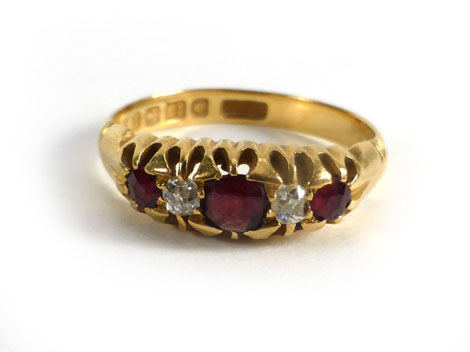 An 18ct yellow gold ring set three graduated rubies interspersed with two small diamonds, size J/K