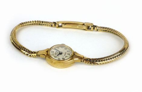 A 9ct yellow gold ladies wristwatch by Rotary, the circular silvered dial on an articulated bracelet