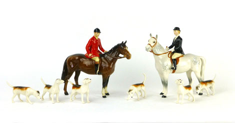 A Beswick hunting group to include a huntsman on a brown horse, hunts lady on a grey horse and six