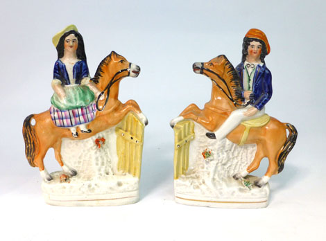 A pair of Staffordshire equestrian figures modelled as horse and rider taking a fence, h. 17.5 cm