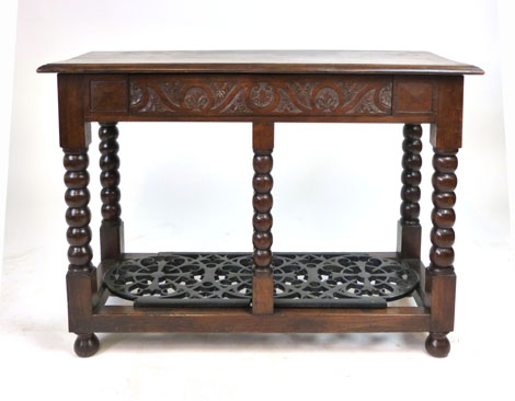 An oak side table with moulded rectangular top above a carved frieze drawer raised on bobbin