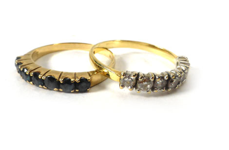 A 9ct yellow gold half eternity ring set sapphires and a yellow metal half eternity ring set