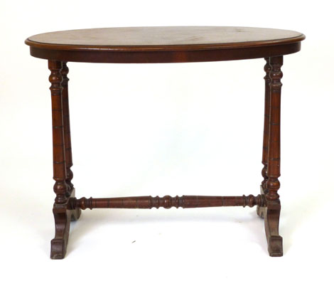 An Edwardian mahogany oval occasional table raised on tapering turned supports with turned stretcher