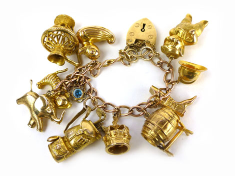 A 9ct yellow gold curb link bracelet with padlock catch suspending ten charms including a pig, a
