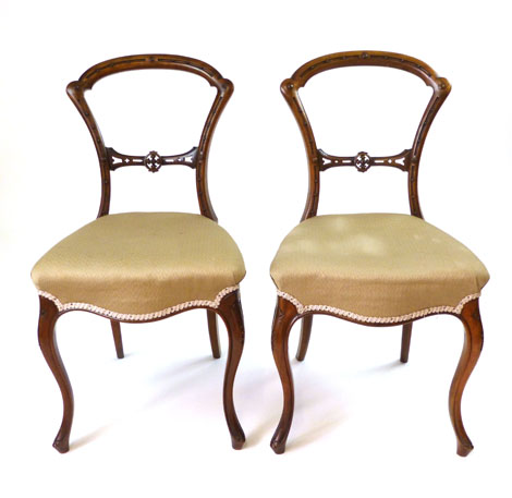 A pair of Victorian walnut salon chairs with arching top rail, pierced back rest, stuffed over