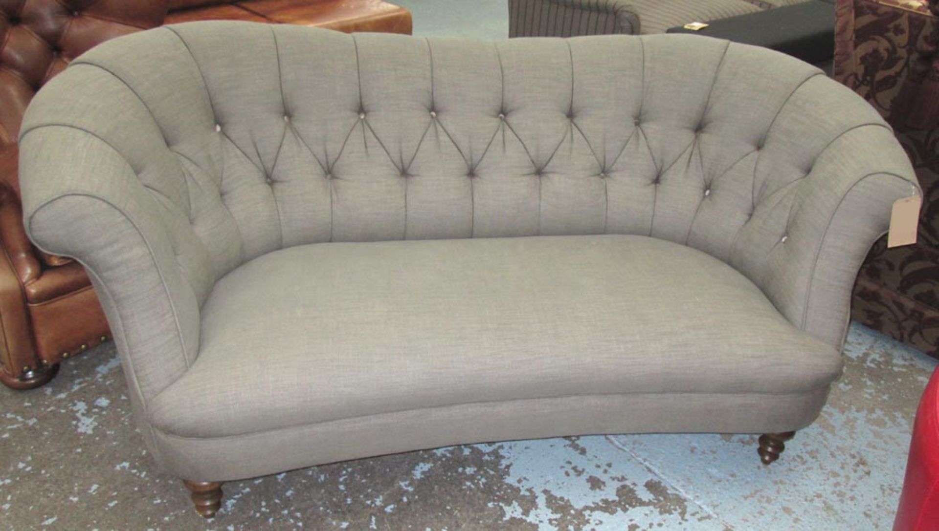 SOFA, with a shaped, buttoned back and grey upholstery on short turned front supports, 205cm L.