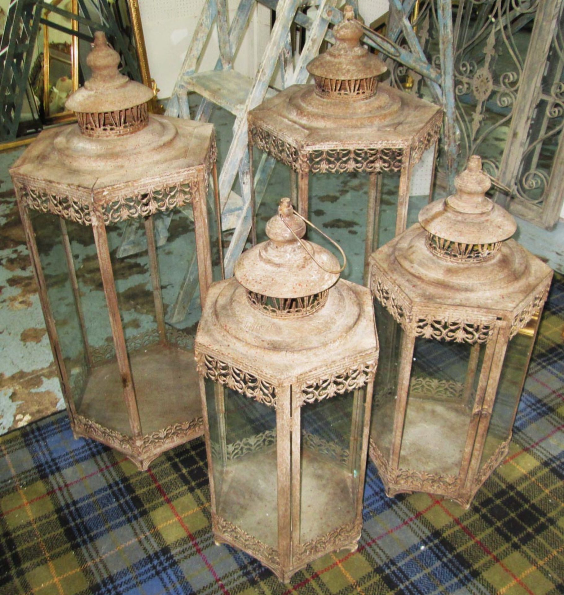 STORM LANTERNS, two pairs, in distressed metal, largest 93cm H and smallest 77cm H. (4)