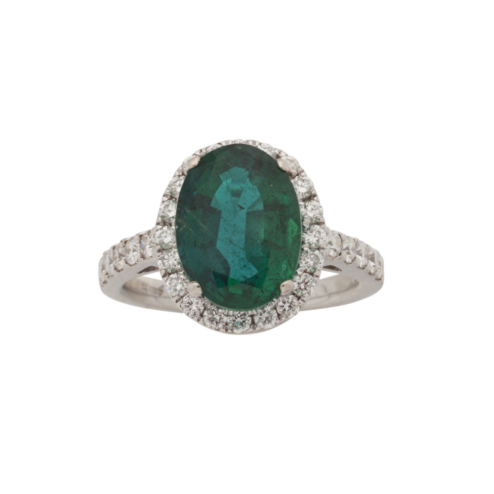 An emerald and diamond cluster ringclaw set to the centre with an oval cut emerald in a single