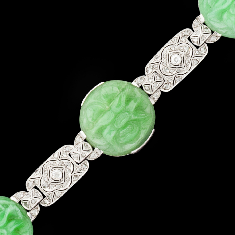 An Art Deco jade and diamond set braceletcomposed of four foliate carved circular jade panels,