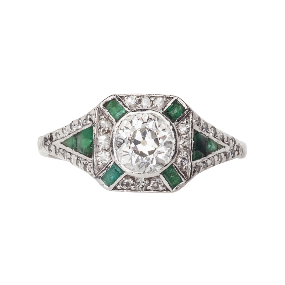 An Art Deco emerald and diamond set ringthe central collet set old European cut diamond, within a