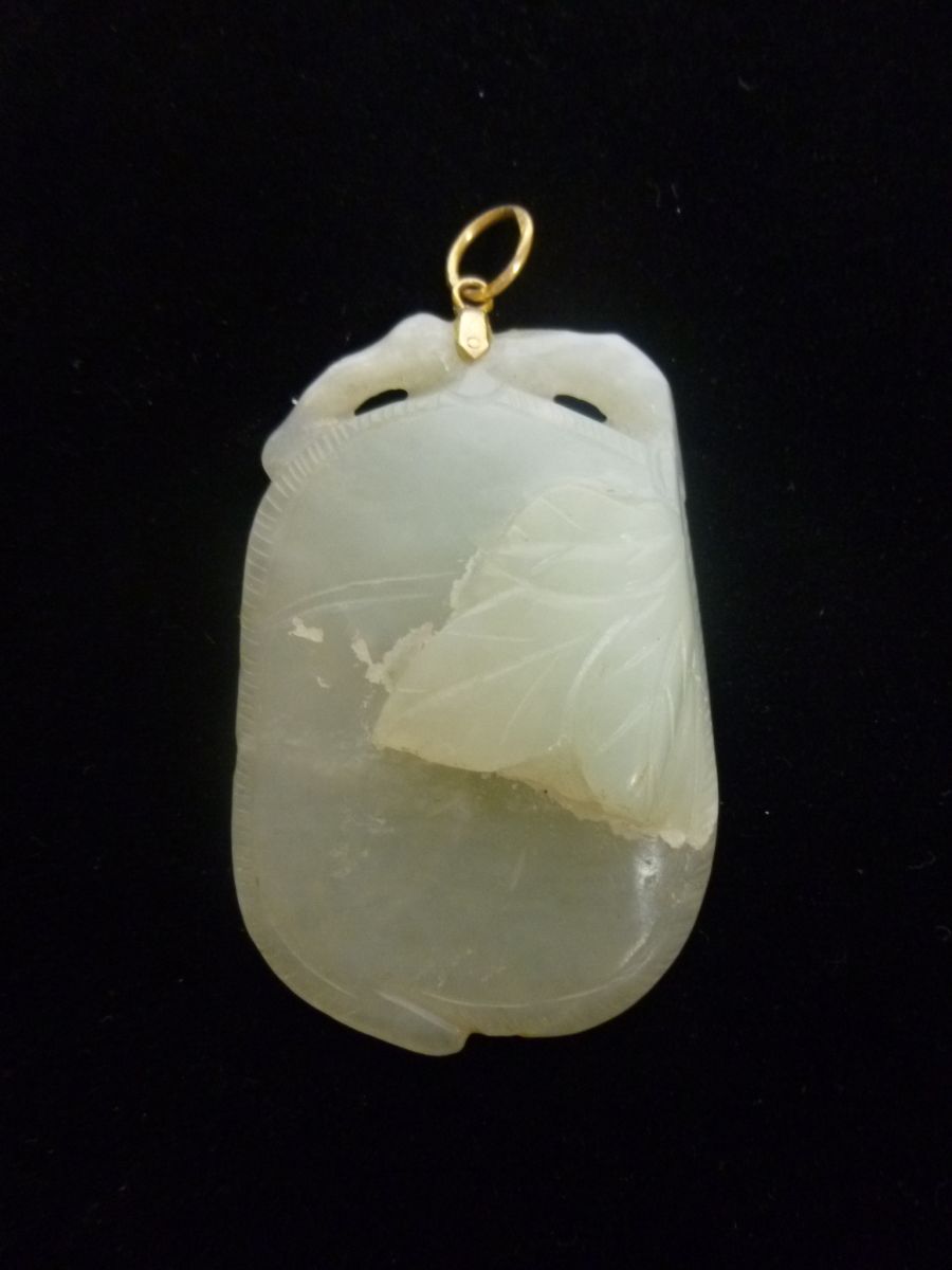 CELADON JADE PENDANTthe rounded pendant carved in relief on one side and incised on the other side,