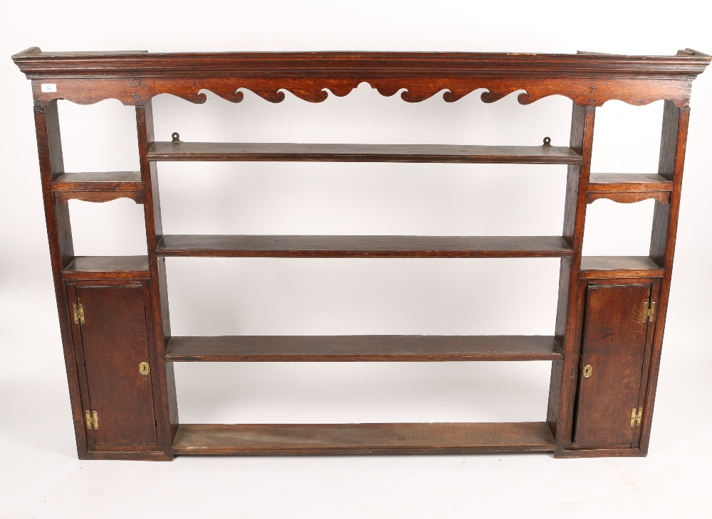 A GEORGIAN OAK PLATE RACK with a central bank of four shelves, flanked on either side by further