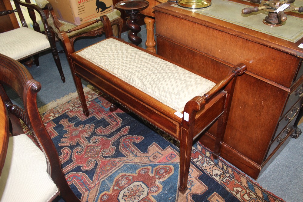 AN EDWARDIAN MAHOGANY DUET PIANO STOOL with hinged box top, scrolling handles and standing on