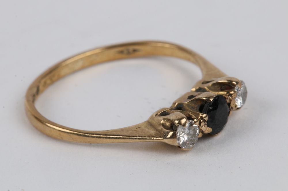 A 9CT GOLD RING with central sapphire, flanked by a diamond to either side