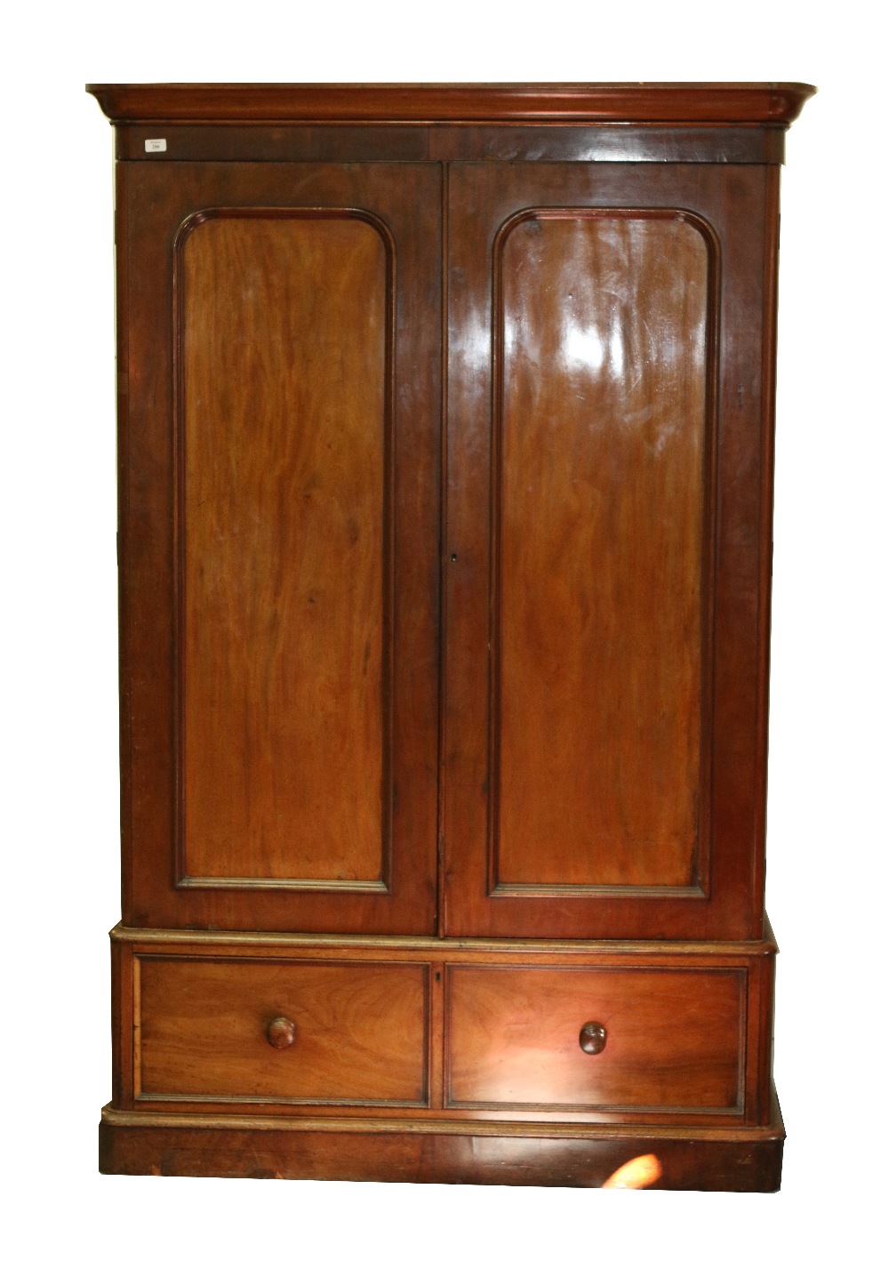 A VICTORIAN MAHOGANY WARDROBE, twin doors with arching panels and single drawer beneath all on a