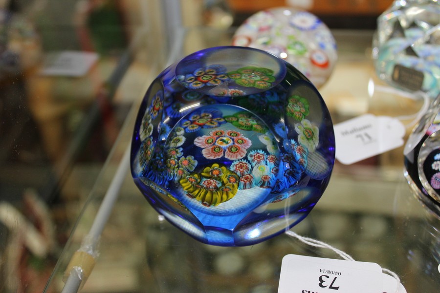 A VENETIAN BLUE OVERLAY PAPERWEIGHT the surface cut with roundels and set with multi coloured canes