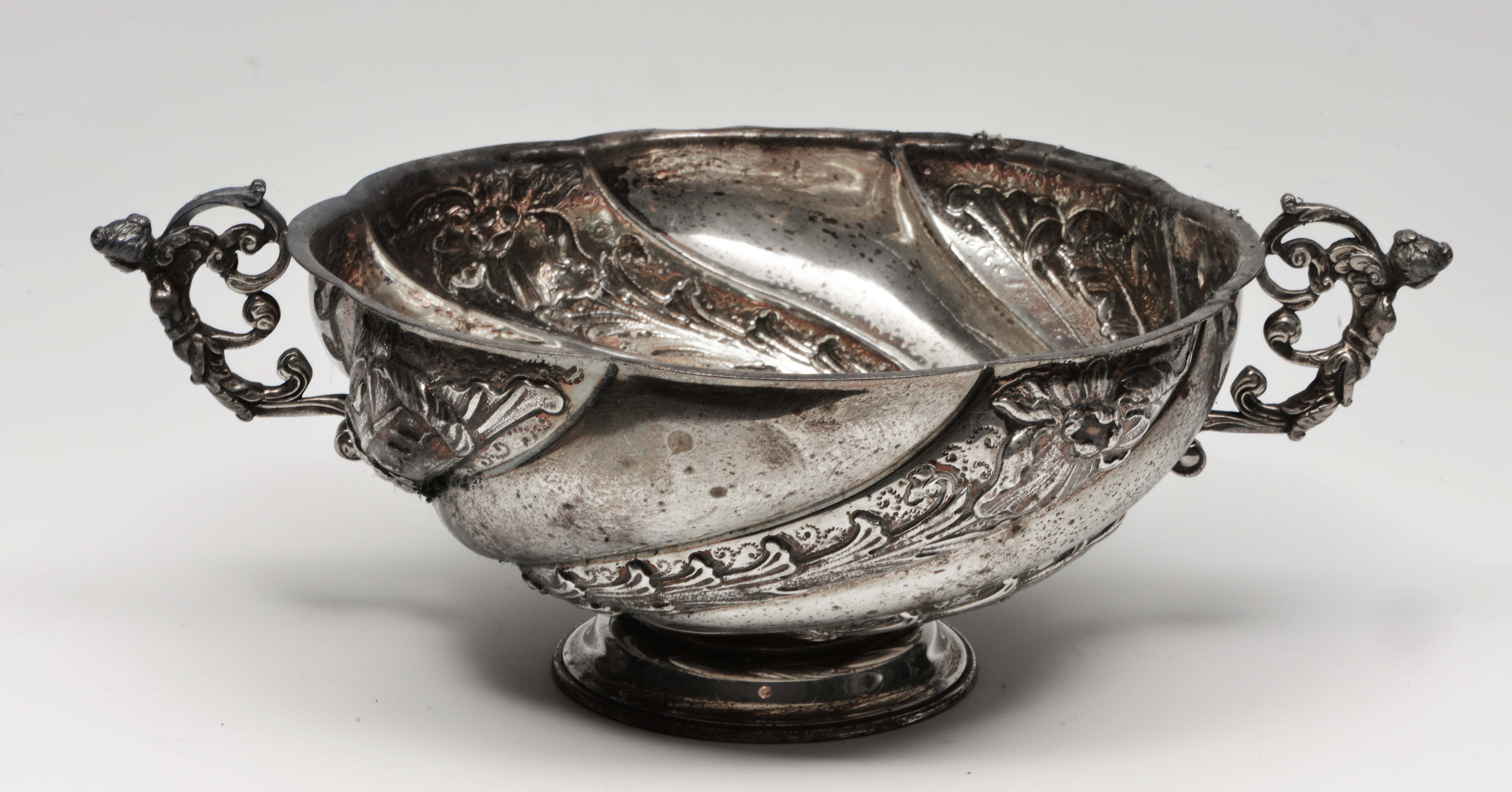 A VICTORIAN SILVER BOWL with two scrolling handles, embossed swirl decoration and a stepped foot