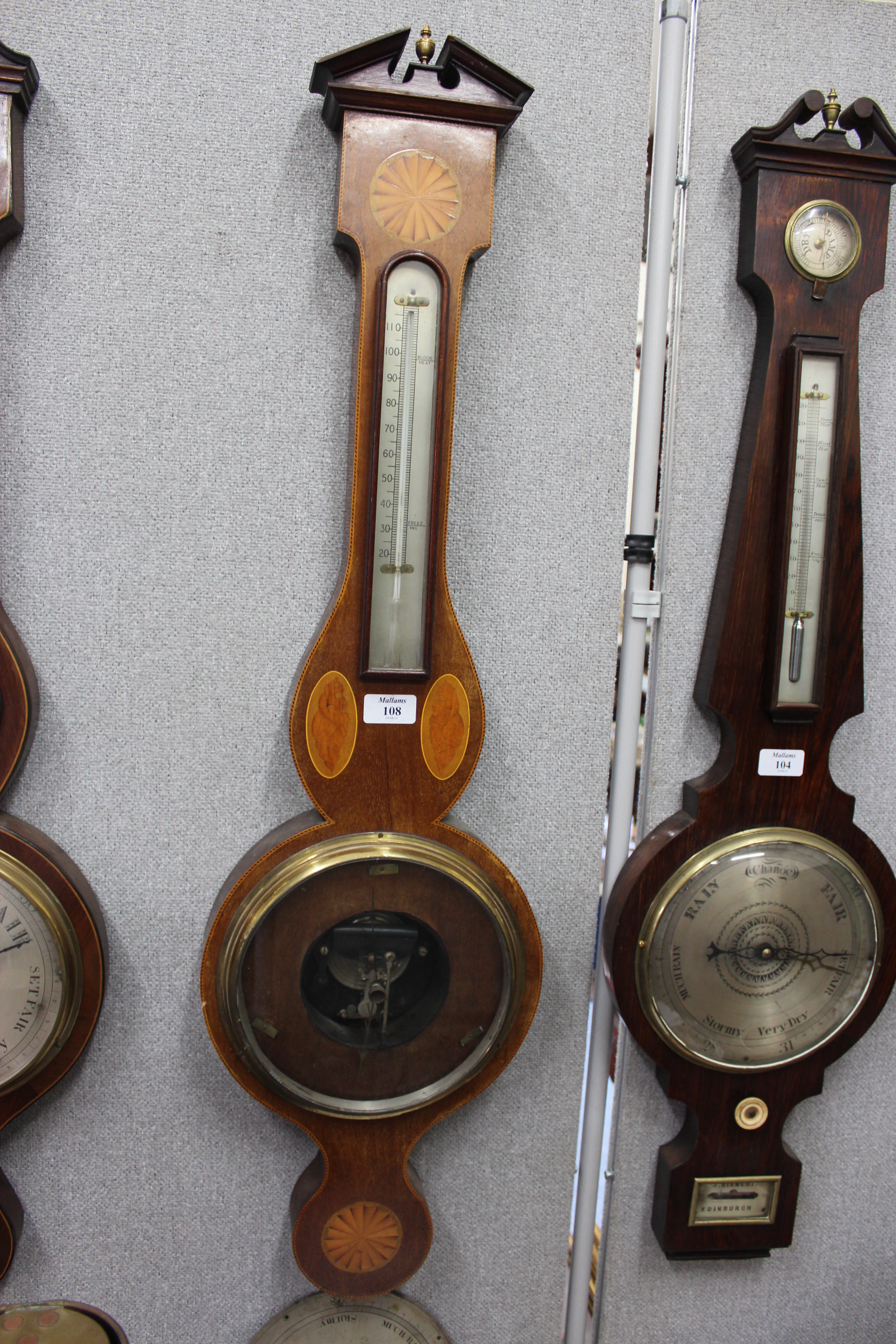 A FINE QUALITY MAHOGANY ANEROID WHEEL BAROMETER with thermometer, the break arch case with brass