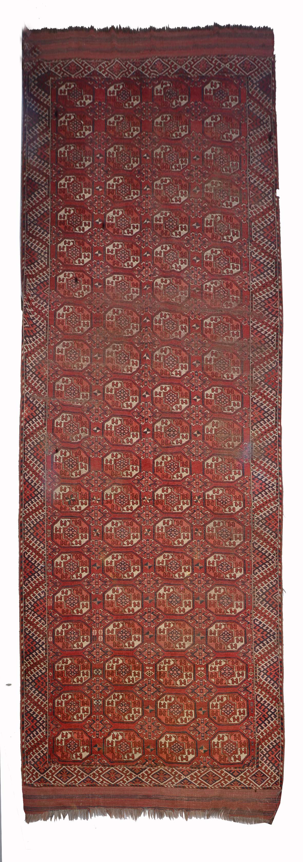 A TURKOMAN KIZIL AYAK  BRICK RED GROUND CARPET decorated four rows of octagons within a hooked