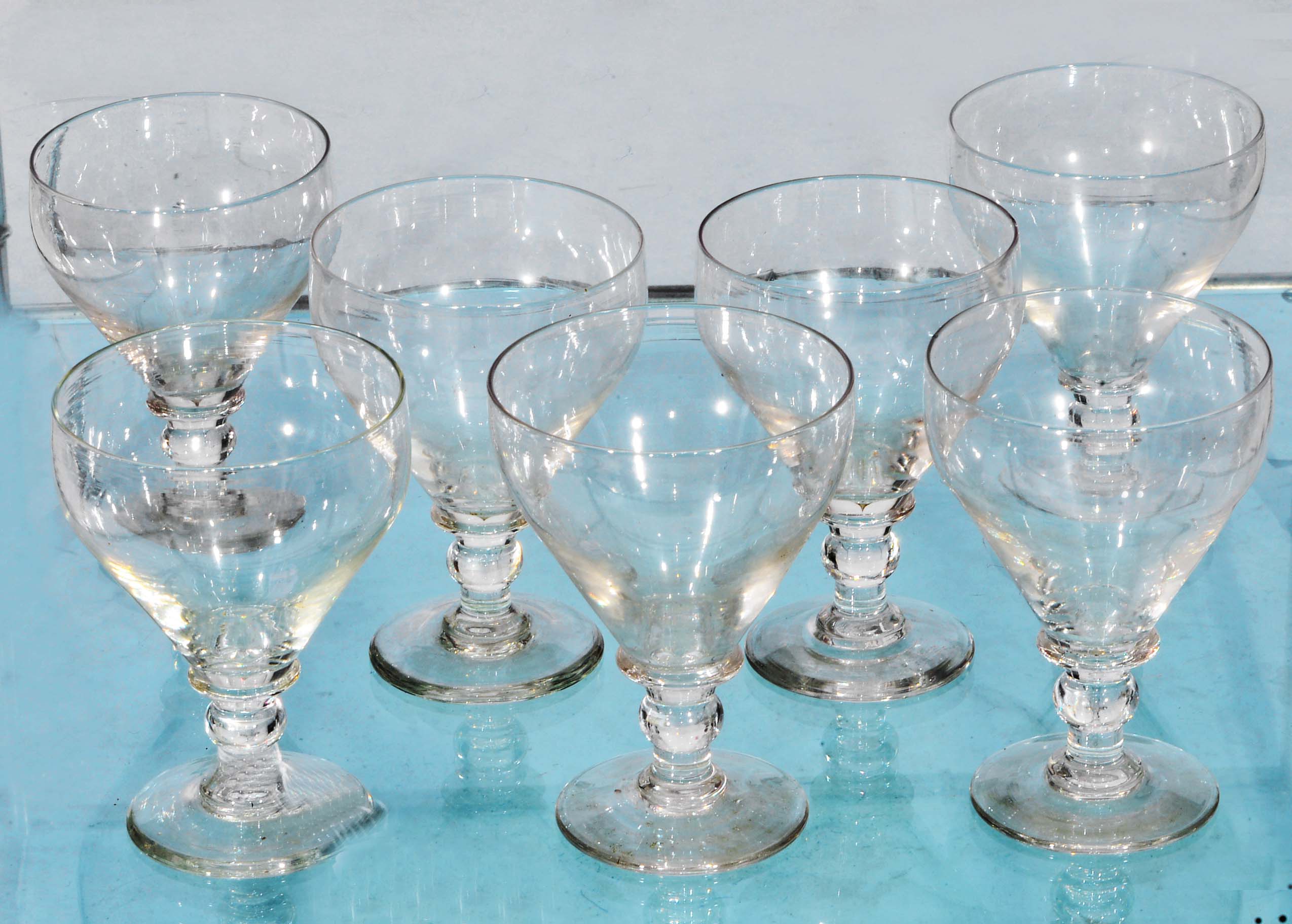 A SET OF SEVEN GEORGIAN STYLE GLASS GOBLETS with baluster knop and circular base 14.5cm high