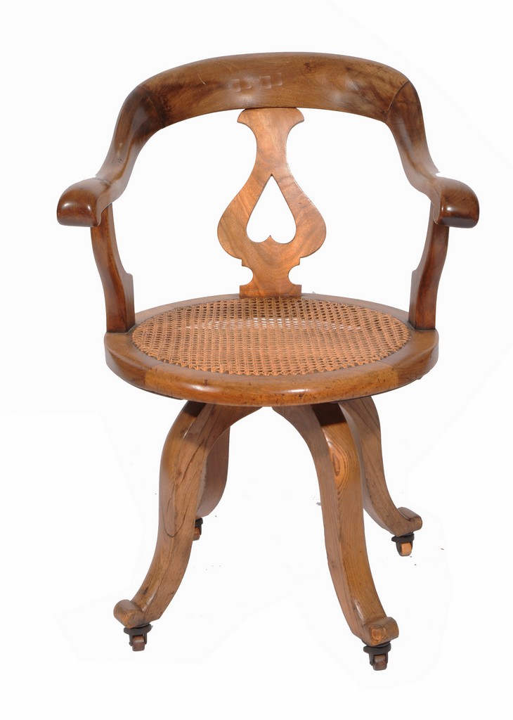 AN OLD DESK CHAIR, the horseshoe shaped back with pierced splat over a circular cane seat and