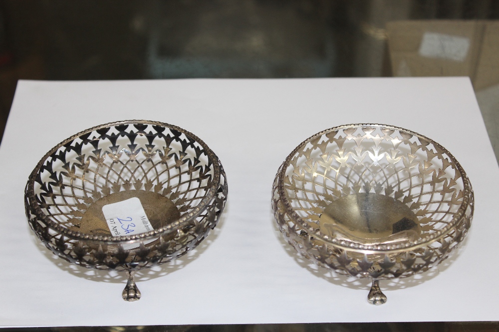 A PAIR OF SILVER OLDFIELD LIMITED PIERCED BASKET standing on short paw feet 10.5cm in diameter