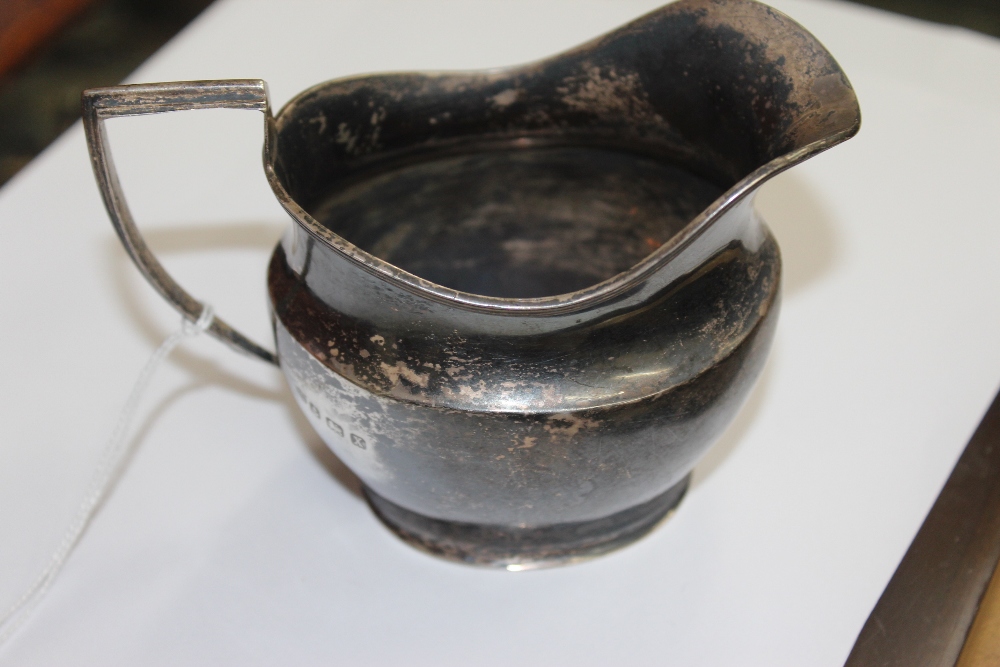 A SILVER CREAM JUG with reeded lip and squared handle, marked Birmingham 1922 approximately 123