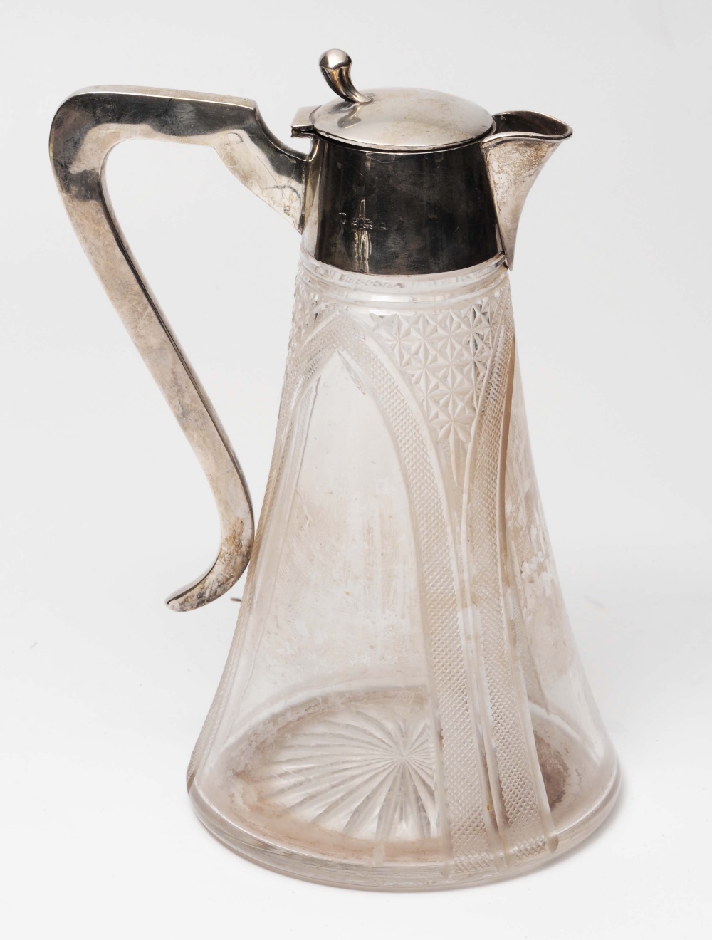 A SILVER MOUNTED GLASS CLARET JUG of tapering form with star decoration, hinged domed lid with thumb