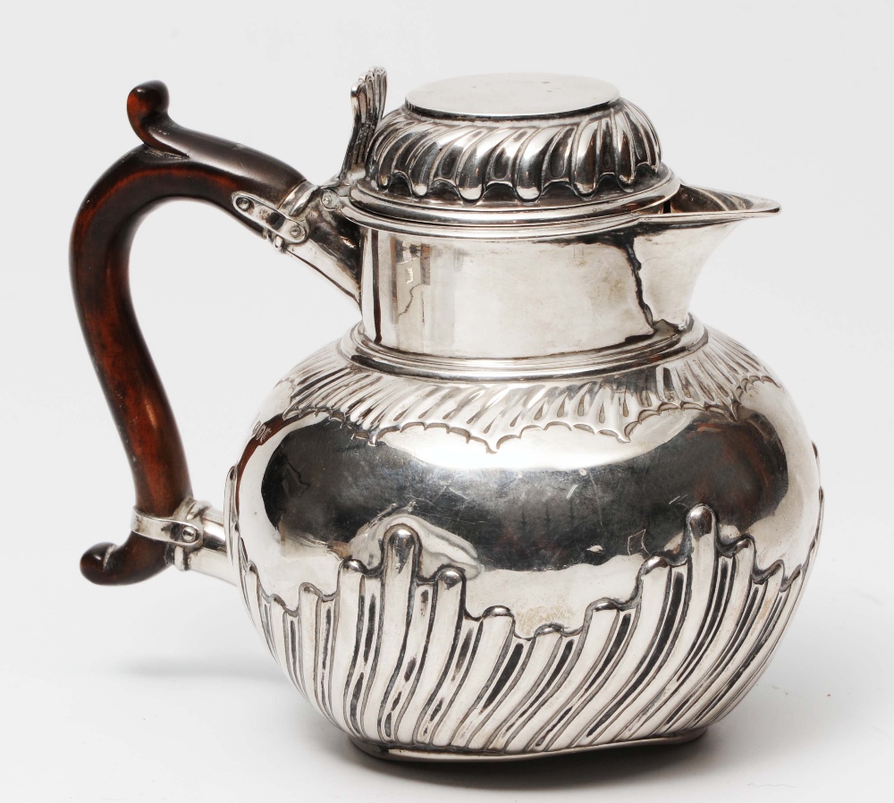 A LATE VICTORIAN SILVER HOT WATER JUG of circular form with fluted lower body, matching domed hinged