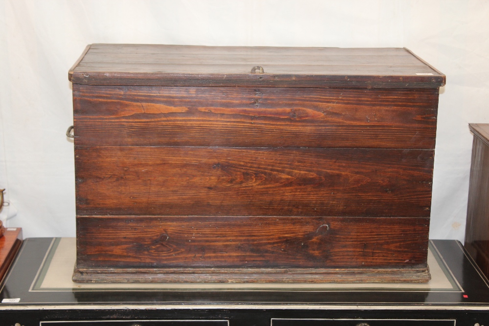 A VICTORIAN PITCHED PINE BOX hinged lifting lid and iron carrying handle either side 97cm wide