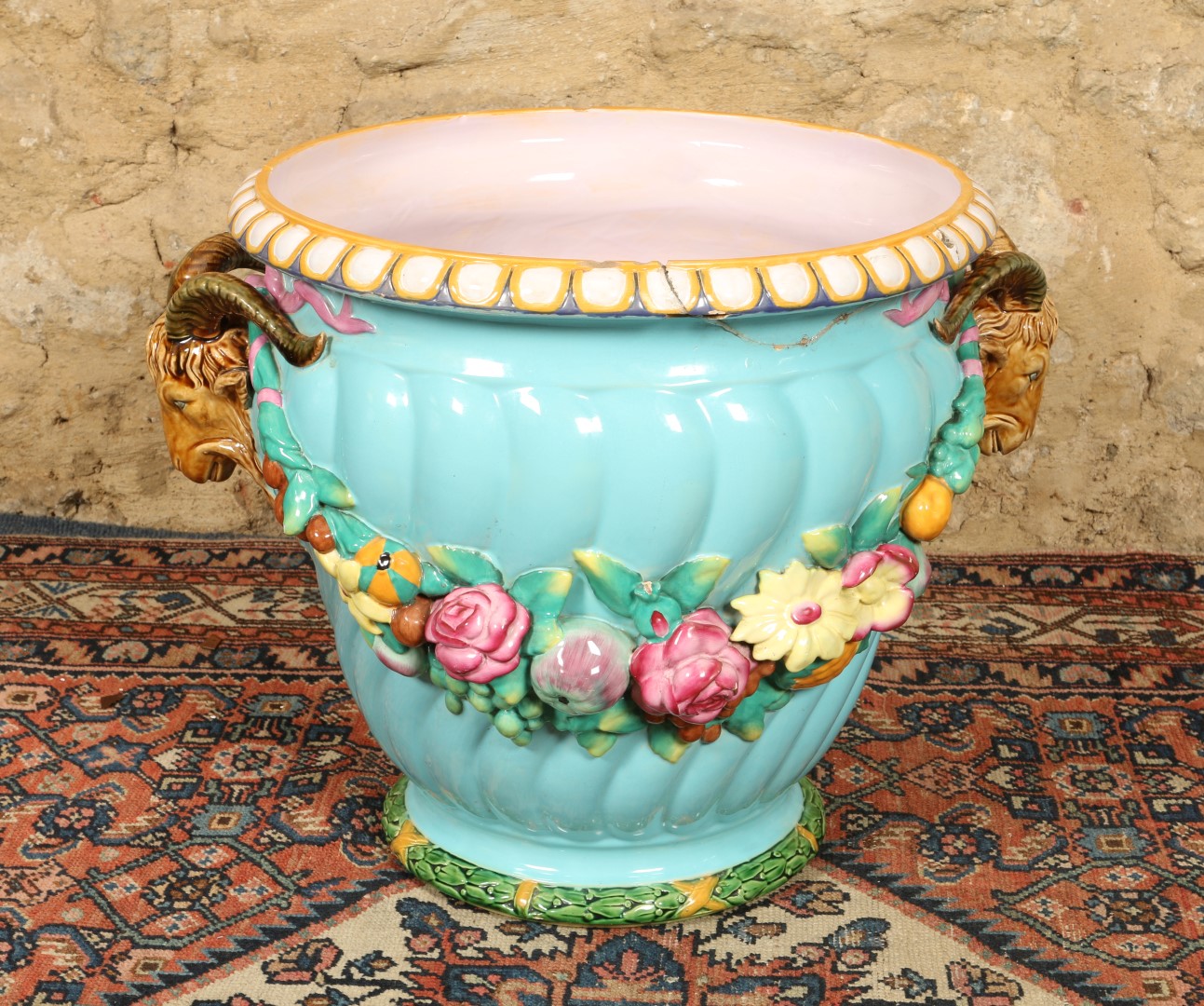 A MINTON MAJOLICA JARDINIERE with polychrome floral swag decoration on a blue ground (old repairs),