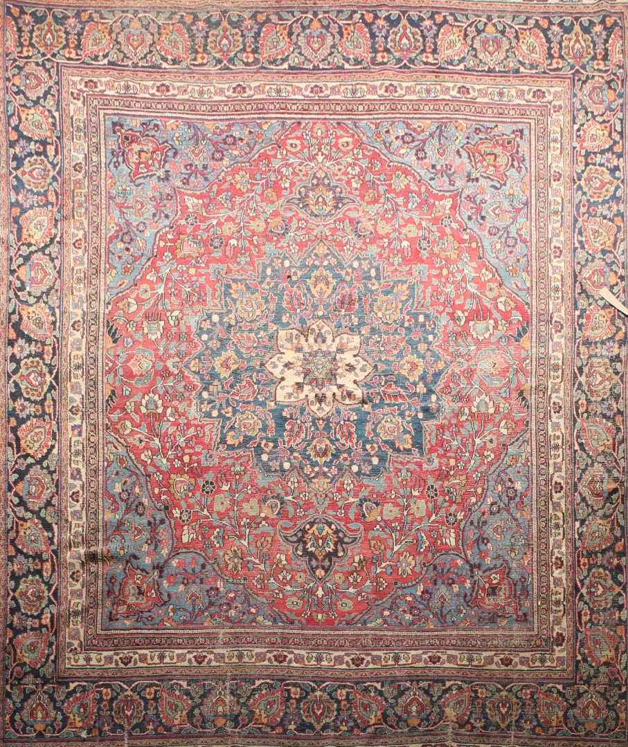 AN OLD PERSIAN COUNTRY HOUSE CARPET with all over foliate design on a red ground (very worn)