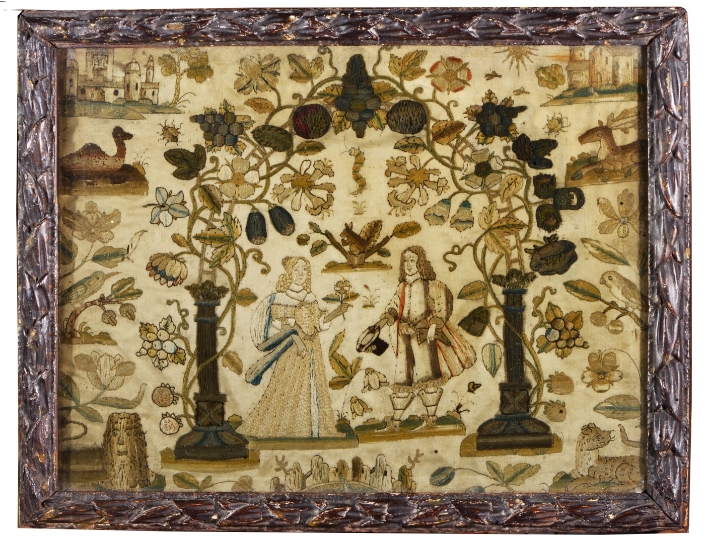 A 17TH CENTURY NEEDLEWORK SAMPLER depicting a nobleman and his wife in an arbour of hanging fruit