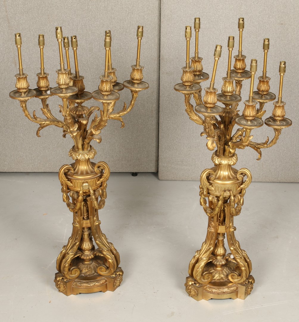 A PAIR OF FRENCH ORMOLU EIGHT BRANCH CANDLE HOLDERS with scrolling acanthus supports and shaped